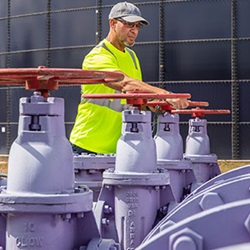 water-reuse-purple-pipes-worker-turning-valve